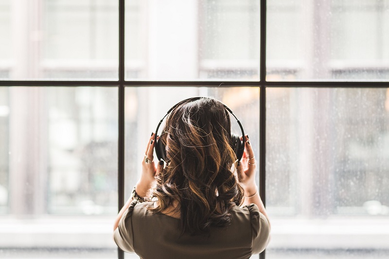 Podcast reizen vrouw voor raam koptelefoon